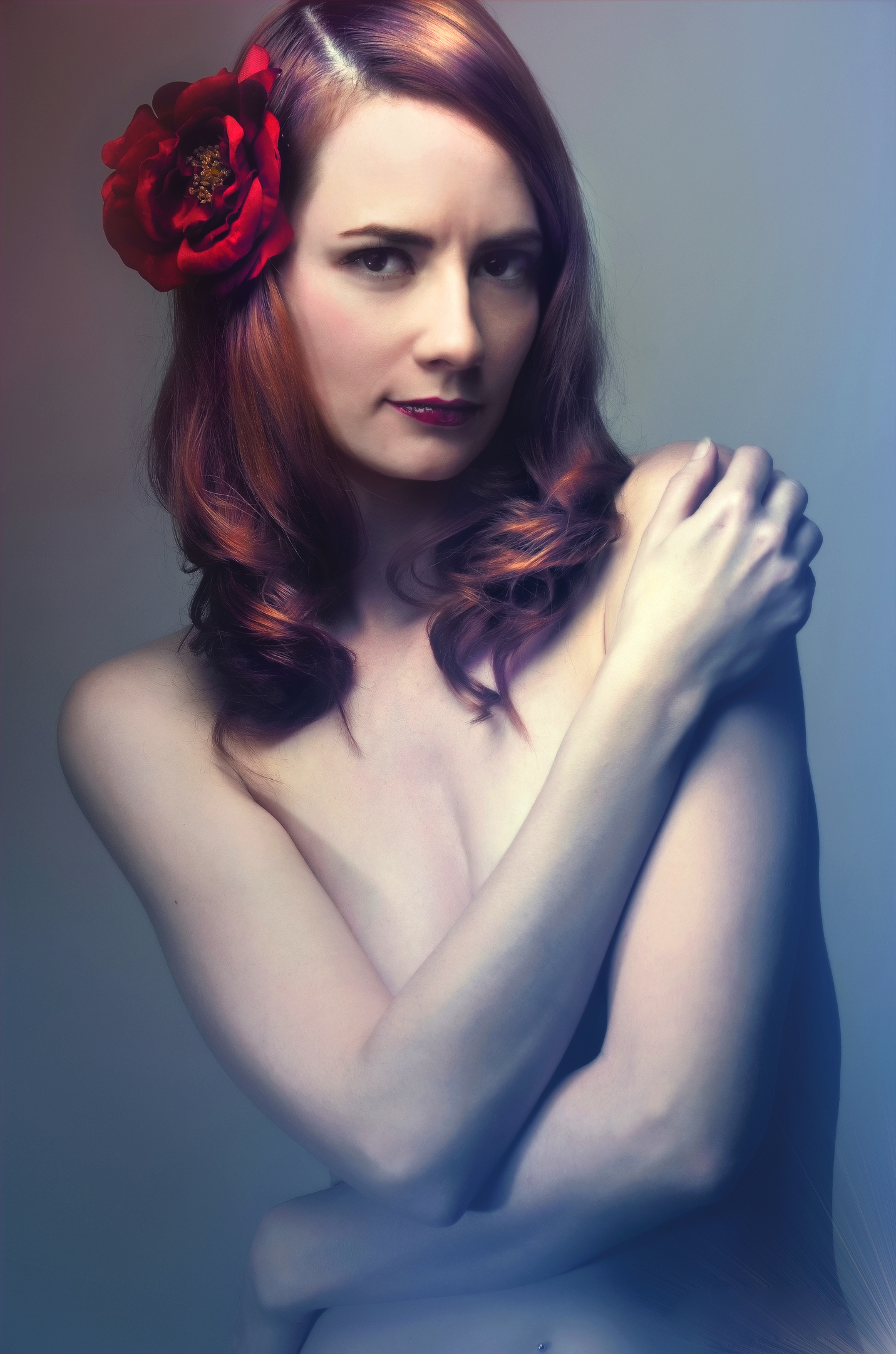 Beauty portrait with red hair and a flower